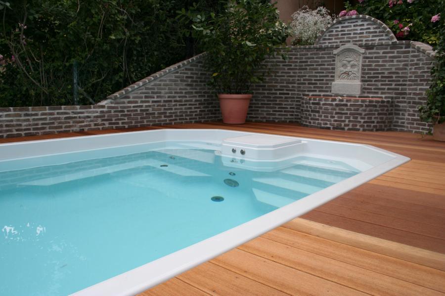 Pool mit Holzdeck und Natursteinmauer