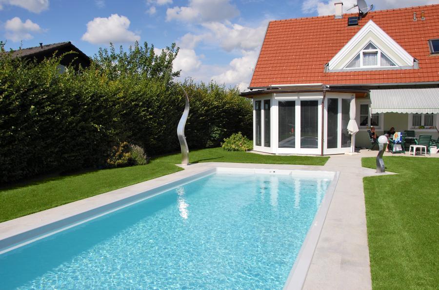 Poolanlage mit Garten und Haus im Hintergrund